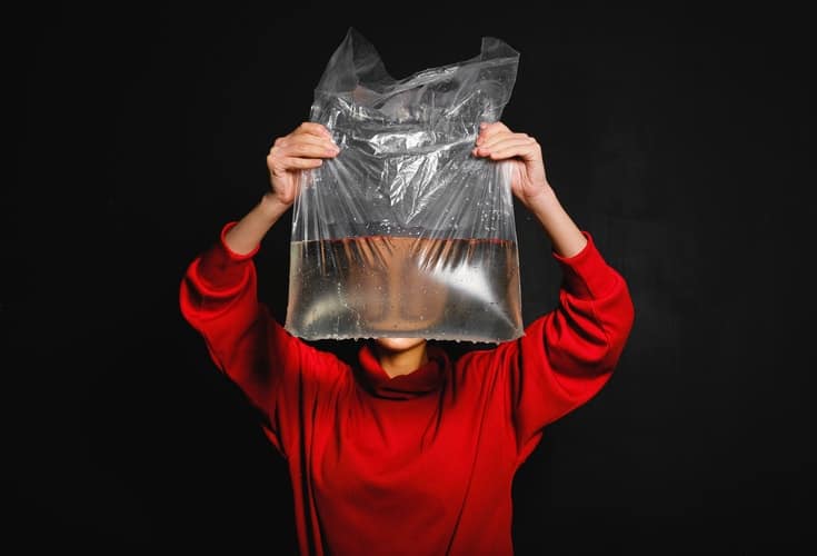 woman holding plastic bag with water